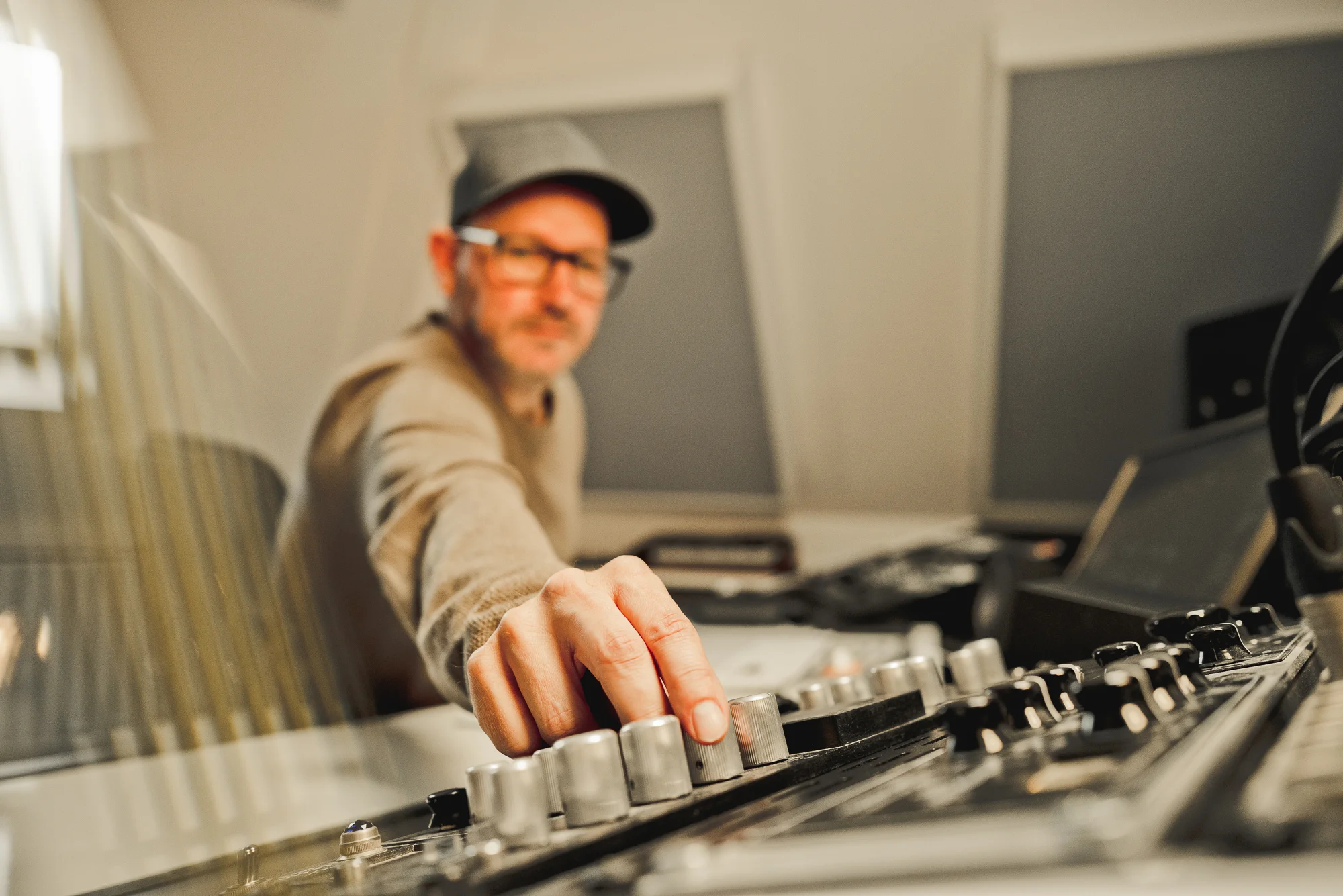Studioaufnahme: Hand am Mischpult mit professionellem Audio-Equipment